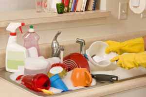 sink full of dishes at home in need of a home cleaner