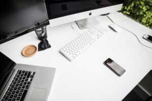 cluttered office desk beside a clean organized workspace